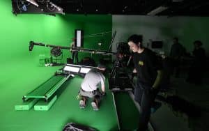 Film crew from Films.Solutions setting up a treadmill in a green screen studio for the U2 project