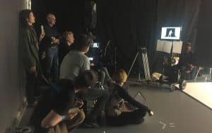 Film crew around the camera, prepping to film U2's member, showcasing Films.Solutions' collaborative spirit