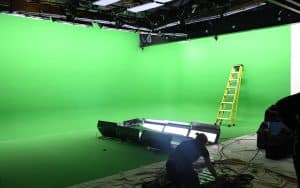 Empty greenscreen studio with a few floor lamps and a technician, prepped by Films.Solutions for U2's 2018 tour video filming