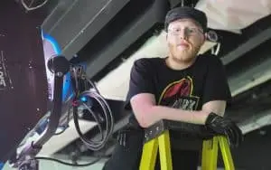 Films.Solutions' Best Boy on a ladder adjusting lighting equipment for U2 project.