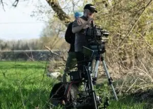 The DOP meticulously setting up the camera, ensuring precision in capturing the scene near the historical crime site.