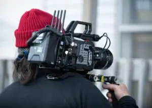 Luka, the 1st assistant camera, with a camera perched on his shoulder, capturing scenes for "Citizen Detective."