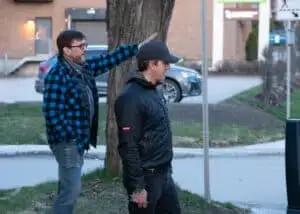 Richard attentively observes something off-frame, with a local citizen detective, engaged in the background.