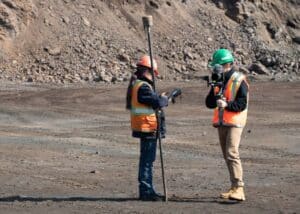Mining specialist discussing the next shot with the cinematographer, holding a GPS stick, in Labrador City mine