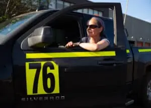 Close-up of the mining specialist fashionably gazing into the distance, standing by her open truck door in a mining environment