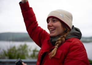 Client liaison officer with a radiant smile, waving hello during the Fay Archive filming in Eastern Canada