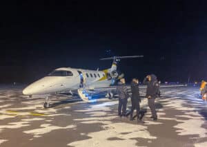 Idris Elba's private plane touching down at Rouyn-Noranda airport, under the dark night sky.