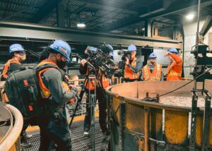 Filming crew capturing the mineral separation process in a boiling mixture at the mine's processing zone.