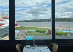 Scenic view from a restaurant near Québec City harbour, overlooking the Saint-Laurent River and a red Canadian Coastguard boat.